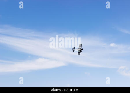 Radio Controlled aeroplano giocattolo contro il cielo blu con nuvole bianche. Modello rc aereo vola nel cielo blu. Aeroplano hobby. Foto Stock