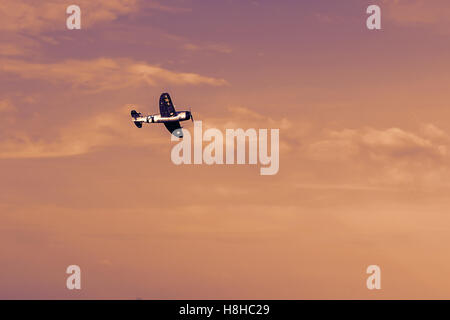 Radio Controlled aeroplano giocattolo al tramonto. Modello rc aereo in volo al tramonto. Aeroplano hobby. Foto Stock