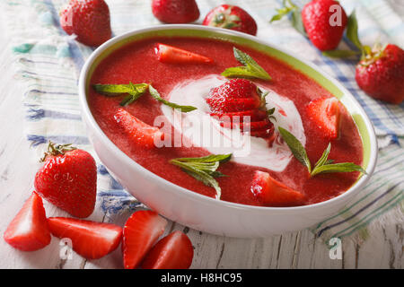 Una deliziosa zuppa di fragole con panna e menta in una ciotola closeup. orizzontale Foto Stock