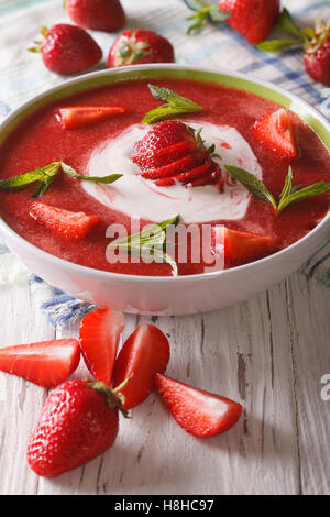 Zuppa di fragole con la menta e panna acida in una ciotola di close-up. In verticale Foto Stock