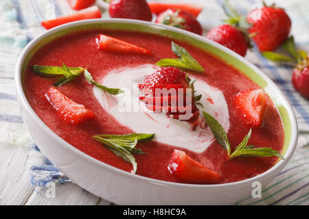 Zuppa di fragole con la menta e panna acida in una ciotola di close-up orizzontale. Foto Stock