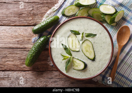 Fredda zuppa di cetriolo con la menta e lo yogurt in una ciotola di close-up. vista orizzontale dal di sopra Foto Stock