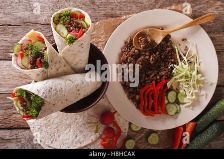 Rotolo di sandwich farciti con manzo e verdure vicino sul tavolo. vista orizzontale dal di sopra Foto Stock