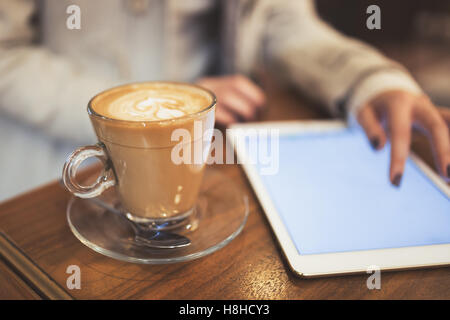 Donna che utilizza tablet nel ristorante mentre si è in pausa caffè