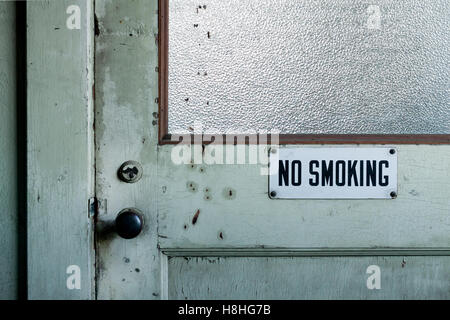 Vietato fumare sulla vecchia porta in fabbrica Foto Stock