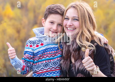 La madre e il figlio che mostra segno ok stand all'aperto in natura Foto Stock