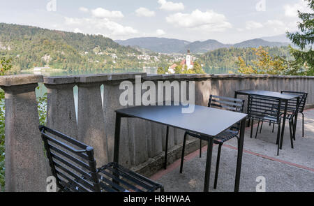 Outdoor Cafe tabelle sopra con vista sul lago di Bled, Alpi, isola e la chiesa dell' Assunzione in Slovenia Foto Stock