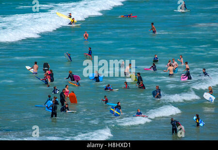 Surfisti di prendere il mare a Fistral Beach in Newquay, Cornwall, England, Regno Unito Foto Stock