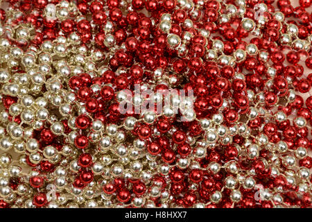 Rosso Argento Natale Mardi Gras beads sfondo. Foto Stock