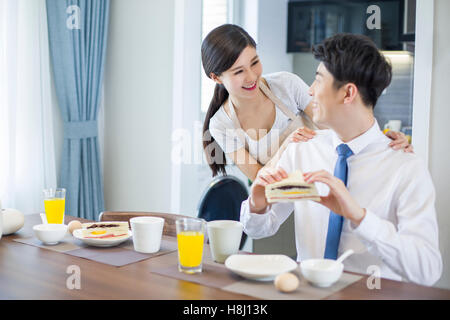 Giovane donna cinese facendo colazione per marito Foto Stock