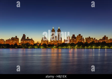 Upper West Side edifici e Central Park Jacqueline Kennedy Onassis serbatoio al crepuscolo in estate. Manhattan, New York City Foto Stock