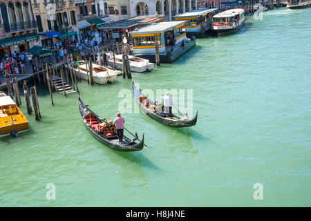 Venezia,Italy-August 17,2014:due gondolieri portano i turisti in una romantica gita sul Canal Grande a Venezia durante un giorno di estate Foto Stock