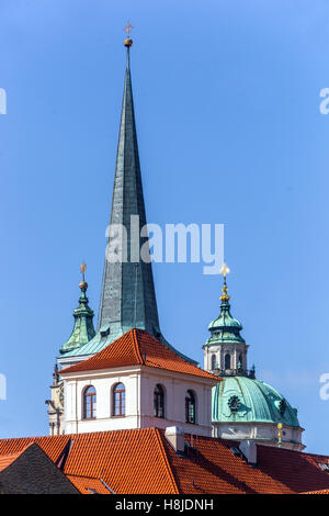 Campanile della chiesa di San Tommaso dell'ordine agostiniano sui tetti di Mala strana, cupola della chiesa di San Nicola, Praga, Repubblica Ceca Foto Stock