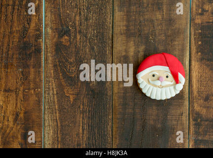 Deliziosi biscotti di Natale con Babbo Natale faccia su una tavola di legno Foto Stock