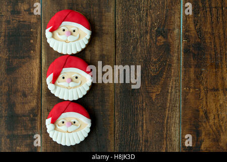 Deliziosi biscotti di Natale con Babbo Natale faccia su una tavola di legno Foto Stock