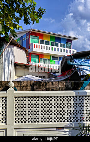 Edificio dipinto a più colori in un ambiente in fase di inattività che offre il concetto di nuovo rispetto a vecchio. Thailandia, S. E. Asia Foto Stock