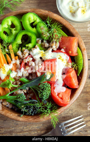 Organico fresca insalata di verdure con grano saraceno in legno rustico ciotola close up Foto Stock