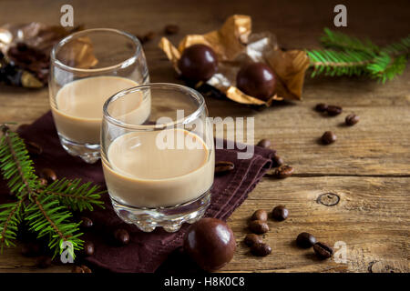 Irish cream liquore al caffè con cioccolatini, Natale ornamenti e decorazioni su legno rustico sfondo - f fatti in casa Foto Stock