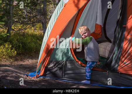 Tabernash, Colorado - due-anno-vecchio Adamo Hjermstad Jr. esce fuori di una tenda in campeggio con la famiglia nelle Montagne Rocciose. Foto Stock