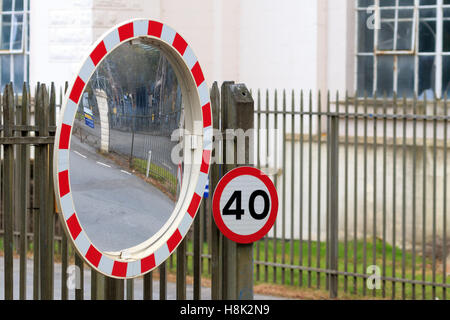 40 MPH segno e la sicurezza del traffico stradale specchio fissato ad un set di ringhiere in acciaio Foto Stock