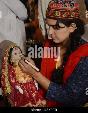 Lahore, Pakistan. Xiii Nov, 2016. Visitatori pakistano tenendo interesse per gli elementi visualizzati durante il secondo giorno del (DAACHI) Arti e Mestieri Fiera mostra organizzata dalla Fondazione Daachi. Prodotti fatti a mano contenente tessuti, ceramiche, Hunza scialli, gioielli etnici, artigianato da Gilgit, Hyderabadi schiave, Phulkari da Haripur, Taxila sculture in pietra, mobili dipinti a mano, chioschi, arte carrello merci, chioschi, dipinti arti e mestieri. © Rana Sajid Hussain/Pacific Press/Alamy Live News Foto Stock