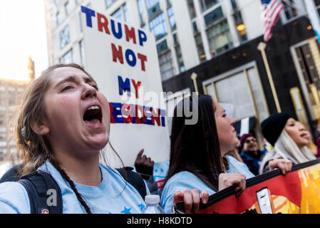 New York, Stati Uniti d'America 12 Novembre 2016 - Cinque giorni dopo le elezioni presidenziali anti-Trump manifestanti marzo dal Trump Hotel and Towers in Columbus Circle, al Trump Tower sulla Quinta Avenue. Il rally dal titolo Siamo qui per questo soggiorno è stato organizzato da diversi gruppi di immigrati in risposta al Presidente eletto Donald trionfi campagna promessa di deportare gli immigrati clandestini. Credito: Stacy Rosenstock Walsh / Alamy Foto Stock