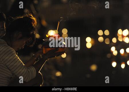 (161114) -- Samut Prakan (Thailandia), nov. 14, 2016 (Xinhua) -- una donna prega prima di impostare a galla un Krathong in un parco a Samut Prakan Provincia, Thailandia, su nov. 14, 2016. Thailandia osservato l annuale Loy Krathong festival il lunedì. Come una tradizione che è stata seguita per almeno sette secoli, le persone insieme a galla lotus-zattere sagomata adornata con candele, incenso e fiori, noto come Krathongs, attorno alla dodicesima notte di luna piena del calendario tailandese e di augurare a un anno con la sfortuna di essere lavati via dalle acque. (Xinhua/Rachen Sageamsak) Foto Stock