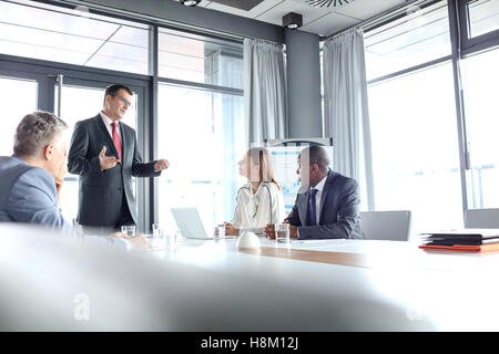 Imprenditore maturo per discutere con i colleghi in sala riunioni Foto Stock