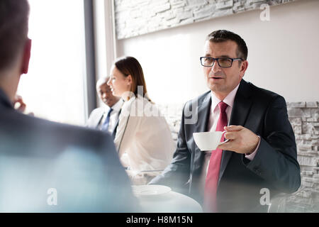 Imprenditore maturo avente il caffè mentre si parla con il collega di sesso maschile in office caff Foto Stock