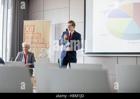 Imprenditore spiegando il grafico a torta nella sala di seminario Foto Stock