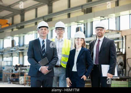 Ritratto di certi uomini di affari che indossa hardhats nell industria del metallo Foto Stock