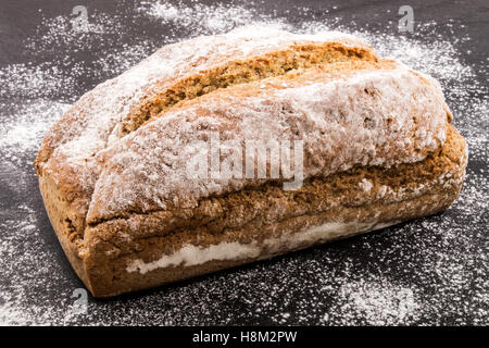 Pane appena sfornato irlandese tradizionale pane di soda con farina sull'ardesia Foto Stock