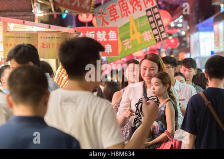 Pechino, Cina - Una folla di persone a piedi attraverso la Donghuamen Snack Mercato Notturno, un grande mercato all'aperto che è un attractio Foto Stock