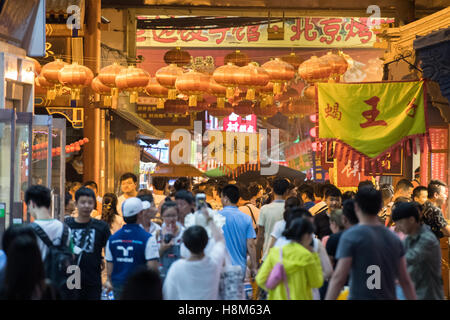 Pechino, Cina - Una folla di persone a piedi attraverso la Donghuamen Snack Mercato Notturno, un grande mercato all'aperto che è un attractio Foto Stock