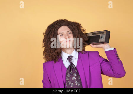 Uomo caucasico con Afro indossa vestito viola l'ascolto di musica Foto Stock