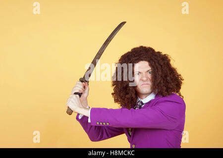 Uomo caucasico con Afro indossa vestito viola che porta la spada Foto Stock