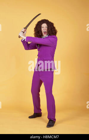 Uomo caucasico con Afro indossa vestito viola che porta la spada Foto Stock