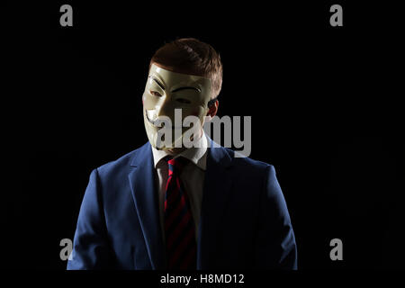 Uomo d'affari sotto la maschera travestimento essendo anonimo e che implica che egli è un hacker o anarchico Foto Stock