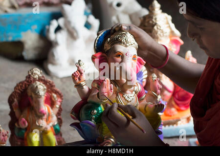 Una ragazza pittura Ganesha idolo, Pune Foto Stock