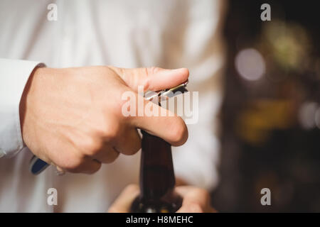 Close-up di barman apertura di una bottiglia di birra Foto Stock