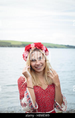 Donna bionda che indossa un fiore tiara in piedi vicino a un fiume Foto Stock