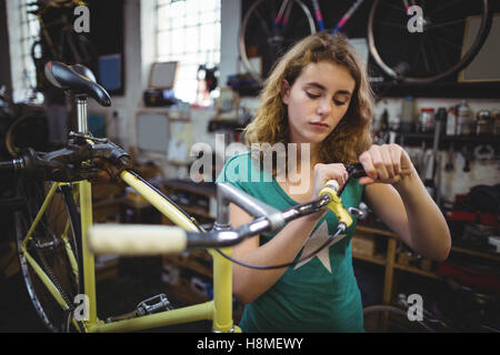 Mechanic esaminando bicicletta Foto Stock