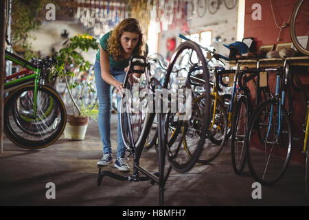 Mechanic esaminando bicicletta Foto Stock