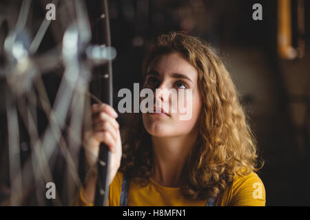 Mechanic esame di una ruota di bicicletta Foto Stock