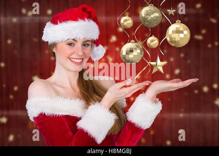 Bella donna in costume di santa fingendo di tenere immaginario decorazioni di Natale Foto Stock