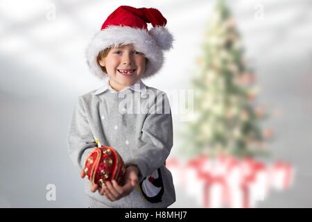 Ragazzo in santa hat holding Pallina natale Foto Stock