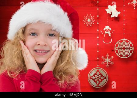 Sorpreso la ragazza di santa hat contro generati digitalmente sfondo Foto Stock