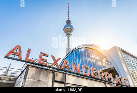 Classic ampio angolo di vista di Alexanderplatz insegna al neon con la famosa torre della televisione e la stazione ferroviaria al tramonto, Berlino, Germania Foto Stock