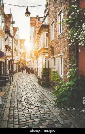 Incantevoli scene di strada in una città vecchia in Europa al tramonto con toni pastello retro vintage filtro e lens flare effetto luce solare Foto Stock