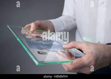 Il futuristico tablet con un display trasparente in mani umane, concetto futuro effettivo di idee innovative Foto Stock